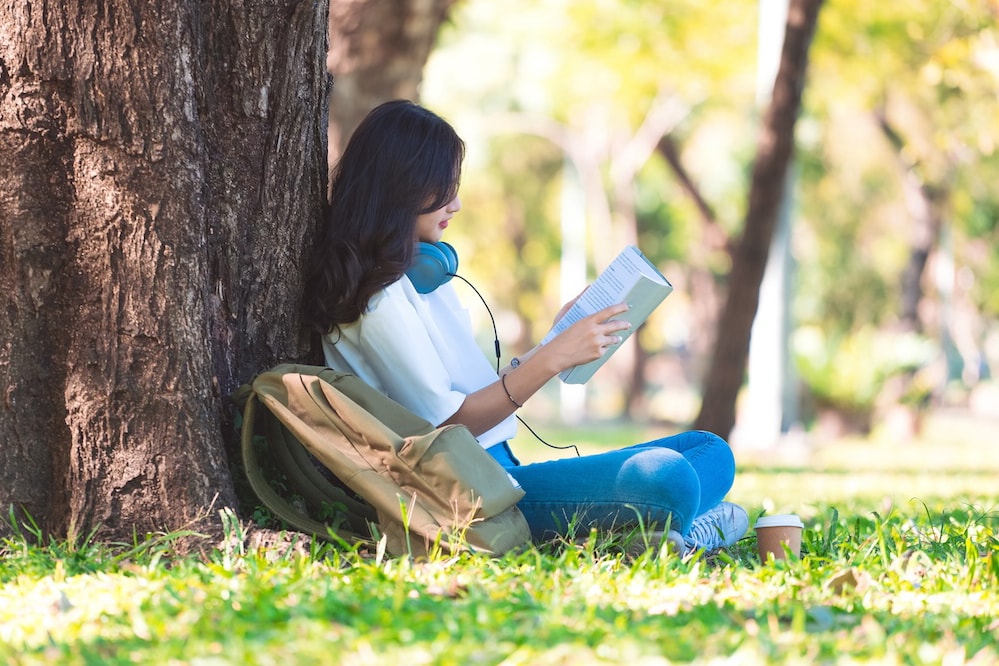 woman reading a most popular language book under a tree