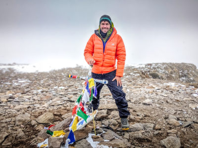 Peter on the summit of Aconcagua in an orange down jacket