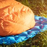 a close up of a down sleeping bag on a camping mat