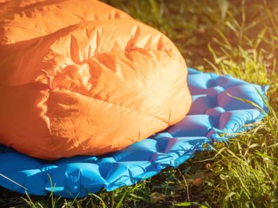 a close up of a down sleeping bag on a camping mat