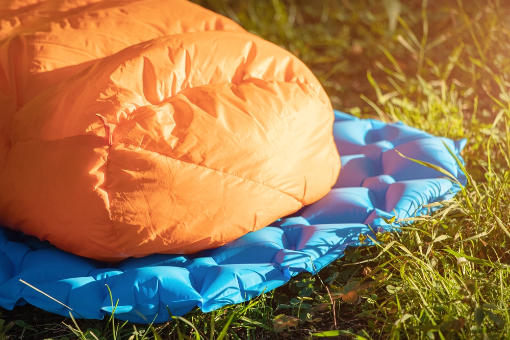 a close up of a down sleeping bag on a camping mat