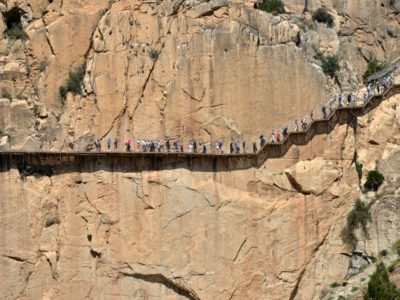 Hikers traverse a cliff hiking trail in Malaga