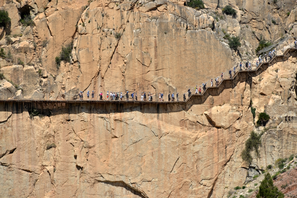 Hikers traverse a cliff hiking trail in Malaga