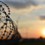 a line of barbed wire at sunset