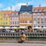 a woman sits beside a canal in Copenhagen