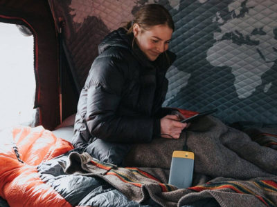 woman in a tent using the best power banks for camping and hiking